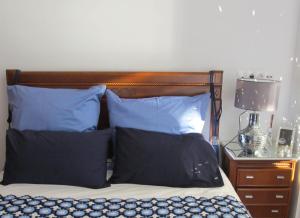 ポルトにあるPorto Douro River Guest Houseのベッドルーム1室(青い枕とランプ付きのベッド1台付)