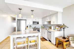 a kitchen with white cabinets and a white counter top at Hale Kai O Kihei in Kihei