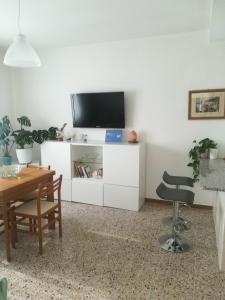 een woonkamer met een tv op een witte kast bij Cepele House in Lignano Sabbiadoro
