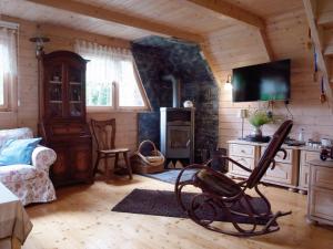 a living room in a log cabin with a tv at Domek w Brzozach in Sasino