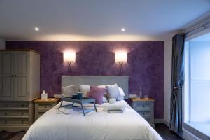ein Schlafzimmer mit einem großen Bett mit einer lila Wand in der Unterkunft The Three Crowns B&B in Plymouth