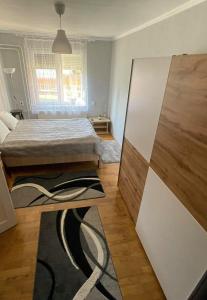 Dormitorio pequeño con cama y alfombra en Rózsa Vendégház en Abádszalók