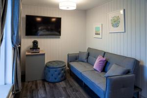 a living room with a blue couch and a tv at The Three Crowns B&B in Plymouth +11 photos