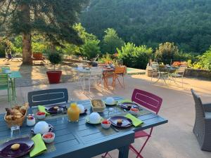 una mesa azul con comida en el patio en Villa La Muse, en Mostuéjouls