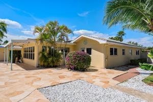 una casa gialla con palme di fronte di Edens Reef, Three configurations to choose from, Lauderdale by the Sea, FL a Fort Lauderdale