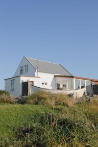 a house with a boat in front of it at Thorshamar sea side villa in Þórshöfn