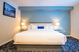 a bedroom with a large white bed with blue walls at Gateway Hotel in Seward
