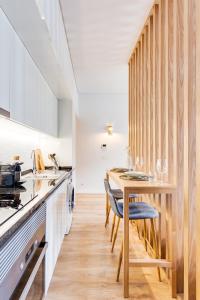 uma cozinha com um balcão de madeira e uma mesa de madeira em DA'HOME - Boavista Blue Studio - NEW no Porto