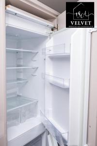 an empty refrigerator with its door open in a kitchen at 1 Bed House at Velvet Serviced Accommodation Swansea with Free Parking & WiFi - SA1 in Swansea
