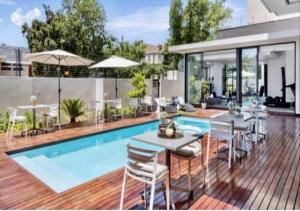 uma casa com piscina com mesa e cadeiras em One Hyde Park Sandton em Joanesburgo