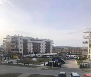 a parking lot with cars parked in front of buildings at Apartament Tuwima 8 in Ełk