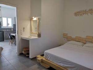 a bedroom with a bed and a mirror on the wall at Family Villages Santorini in Vlychada Beach