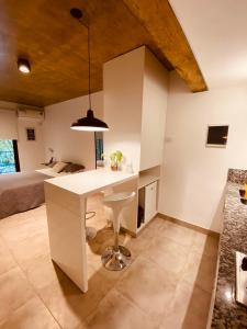 uma cozinha com uma ilha branca num quarto com uma cama em Studio II em Belén de Escobar