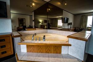 a large bath tub in a kitchen with a sink at Companion Hotel Motel in Hearst +9 photos