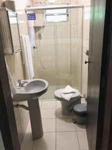 a bathroom with a sink and a toilet and a shower at Hotel Pousada Mar Azul in Itapoa +50 photos