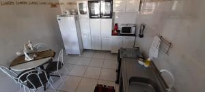 a small kitchen with a sink and a refrigerator at Ap07-A 50 Metros da Praia Flats Completamente Mobiliados in Paulista