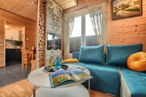 een woonkamer met een blauwe bank en een tafel bij Przystanek Skandynawia in Uherce Mineralne