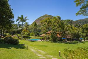 a path leading to a resort with mountains in the background at Pousada Parador Santarém in Itaipava