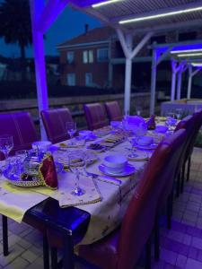 a long table with plates and glasses on it at Maison Duffal in Azrou