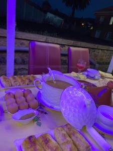 a table with food and a bowl of soup and bread at Maison Duffal in Azrou