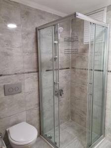 La salle de bains est pourvue d'une cabine de douche et de toilettes. dans l'établissement Side Özgürhan Hotel, à Sidé
