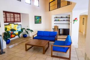 a living room with blue chairs and a table at Villa Noche in San Juan del Sur