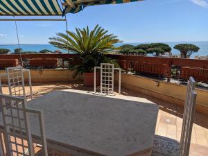 uma mesa e cadeiras em cima de uma varanda em Attico Panoramico Vista Mare em Anzio