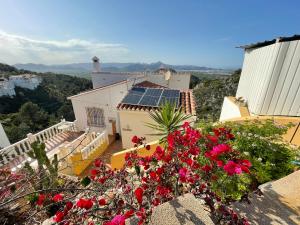 uma vista para uma casa com flores vermelhas e um telhado em Villa Arturo Tossal Gross em La Font D´En Carròs