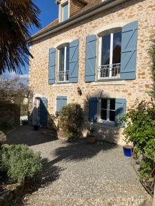 a brick house with blue shutters on it at chambre privée in Lombron