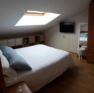 een slaapkamer met een groot bed en een dakraam bij Disfruta Teruel in Teruel