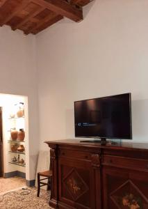 a flat screen tv sitting on top of a wooden entertainment center at Casa La Fornace in Fornacette