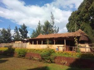 una casa con un tetto di paglia e una recinzione di Sipi Coffee Lodge a Kapchorwa