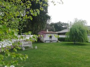 einen Hinterhof mit einem weißen Haus und einem Rasen in der Unterkunft Casona Del Duende in Alájar