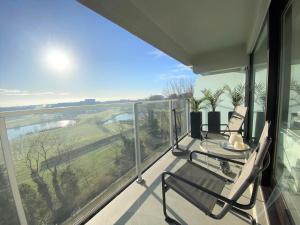 een balkon met twee stoelen en een tafel erop bij La Perle d´Ostende in Oostende