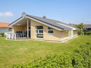 ein kleines gelbes Haus mit einem großen Hof in der Unterkunft 12 person holiday home in GROEMITZ in Grömitz