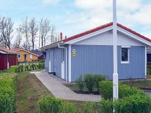a blue house with a pole in front of it at 4 person holiday home in GROEMITZ in Grömitz