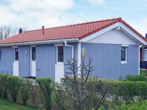 Casa azul y blanca con techo rojo en 4 person holiday home in GROEMITZ, en Grömitz
