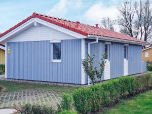 una pequeña casa azul con techo rojo en 4 person holiday home in GROEMITZ, en Grömitz