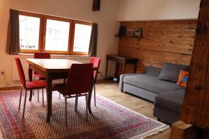 sala de estar con mesa, sillas y sofá en Ferienwohnung Unterdorf, en Göschenen