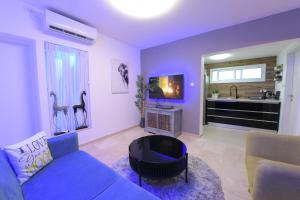 een woonkamer met een blauwe bank en een tv bij יחידת יוקרה נועם in Eilat