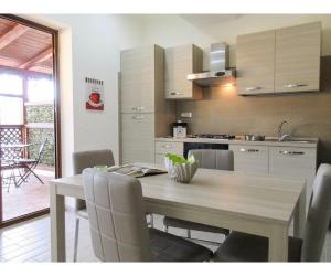 uma cozinha com uma mesa com cadeiras e uma sala de jantar em Mare e Monti em Trivio