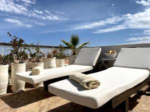 2 witte ligstoelen op een patio met uitzicht op de oceaan bij Maison Du Tresor in Marrakesh