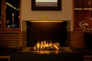 a fireplace in a living room with fire in it at Hotel Ambiance Superior in Zermatt