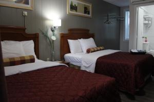 パリーサウンドにあるSunrise Innのホテルルーム ベッド2台(赤いシーツ付)