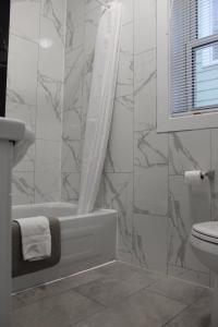 a bathroom with a tub and a toilet at Sunrise Inn in Parry Sound