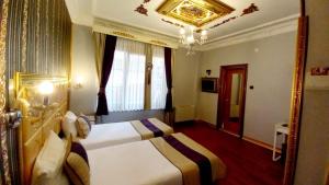 a hotel room with two beds and a chandelier at Bakirkoy Tashan Business & Airport Hotel in Istanbul