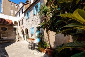 een steegje in een oud gebouw met een palmboom bij Old Town Luxury House in Split