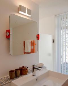 a bathroom with a sink and a mirror on the wall at Les Milles Roches in Gordes +46 photos