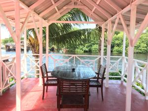 een tafel en stoelen op een veranda met uitzicht op het water bij Easy Inn Hotel in Belize City