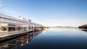 a large building next to a body of water at Finlandia Hotel Alba in Jyv&auml;skyl&auml;